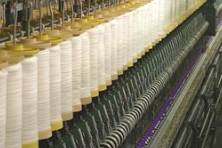 bobbins of wet spun fine long line bleached flax yarn on the spinning machine